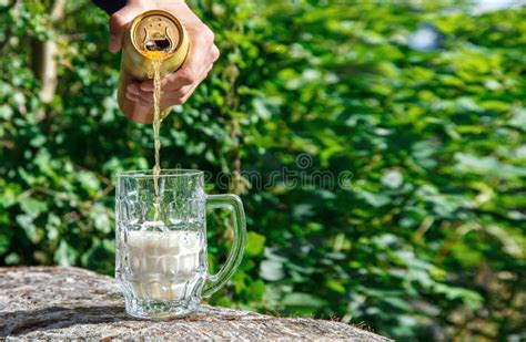 Equipe A Cerveja De Derramamento De Um Frasco Em Uma Caneca Foto De