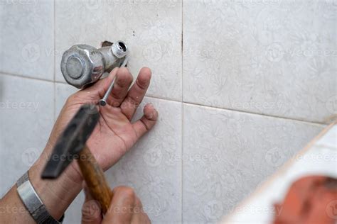 Asian man tries to fix and repair pipe shower in the old restroom ...