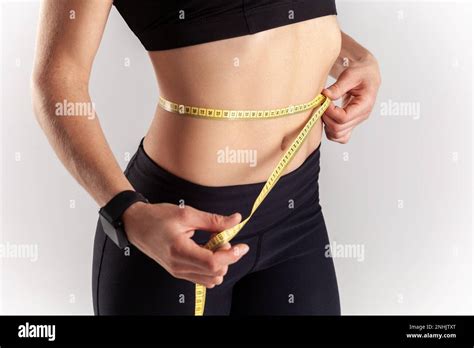 Portrait Of Anonymous Sporty Blonde Woman Holding Centimeter On Her