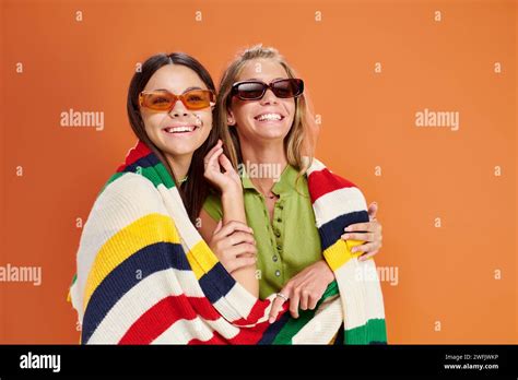 Cheerful Blonde And Brunette Teenage Girls With Sunglasses Hugging And Looking At Camera