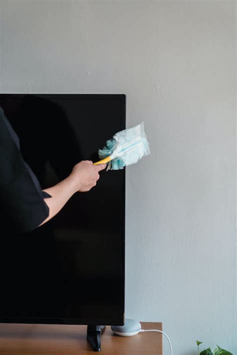 A Person Dusting A Tv Set · Free Stock Photo
