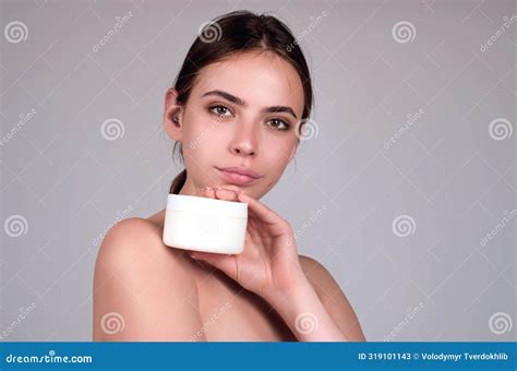 Beauty Portrait Of A Beautiful Half Naked Woman Applying Face Cream