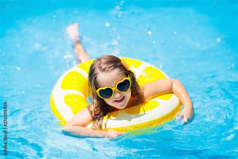 Child in swimming pool on ring toy. Kids swim. Stock Photo | Adobe Stock