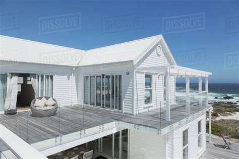 White Beach House With Balcony With Ocean View Under Sunny Blue Sky