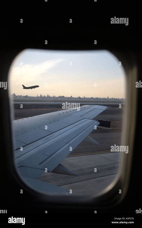 View of plane taking off through window of plane on ground United ...