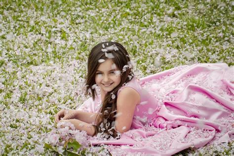 Little girl on green grass with petals Stock Photo by ©Tverdohlib.com 111808834