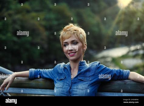Portrait Of Beautiful Blonde Woman Leaning With Her Back And Arms Outstretched Relaxed On A