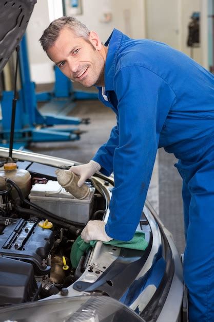 Premium Photo Mechanic Pouring Oil Into Car