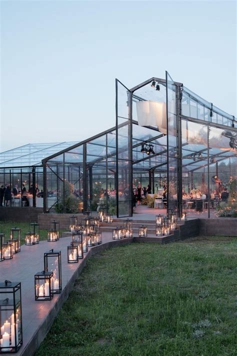 Many Lit Candles Are Placed In Front Of A Glass House