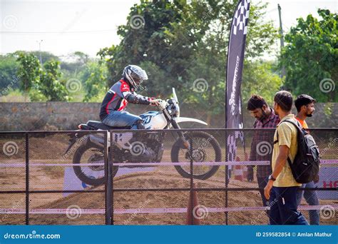 Spectators Watching Off Road Bike Racing Event With Xpulse Bike Going Over Jump Behind Fence