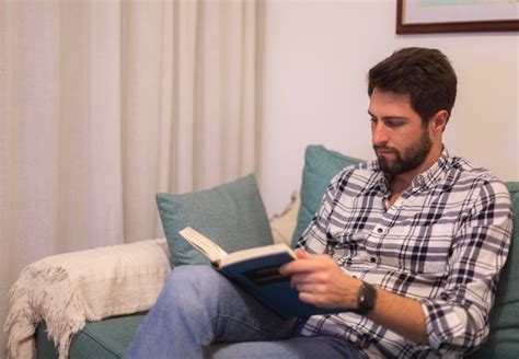 Premium Photo | A man reading a book on a couch