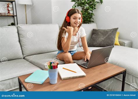 Joven Adolescente De Brunette Haciendo Deberes Con Una Laptop En Casa