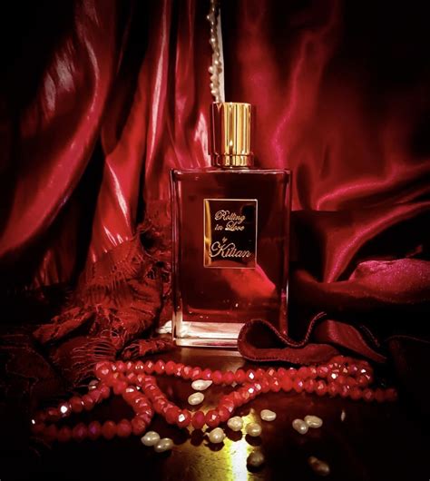 a bottle of perfume sitting on top of a table next to a beaded necklace
