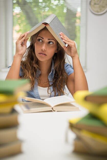 Retrato De Una Hermosa Adolescente Sosteniendo Un Libro Sobre La Cabeza