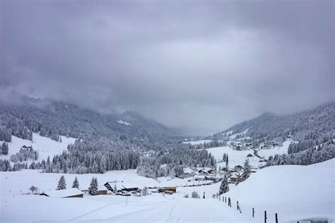 A snow covered mountain with a village in the distance photo – Free ...