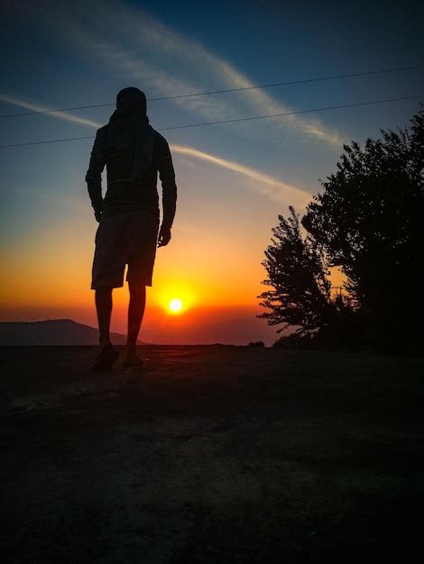 Premium Photo Rear View Of Man Walking On Road During Sunset