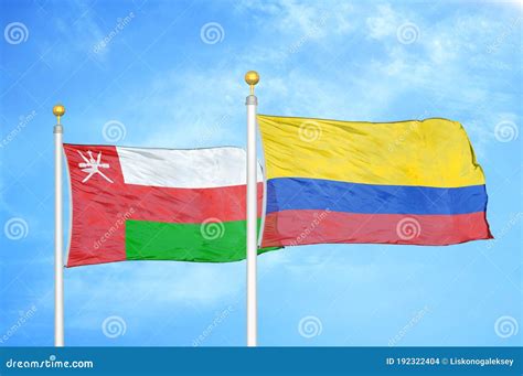 Oman And Colombia Two Flags On Flagpoles And Blue Sky Stock Photo