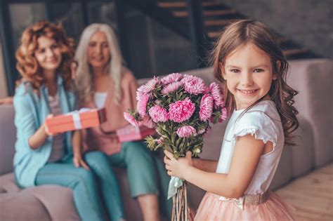 Ni A Sosteniendo Un Ramo De Flores Y Sonriendo A La C Mara Mientras La