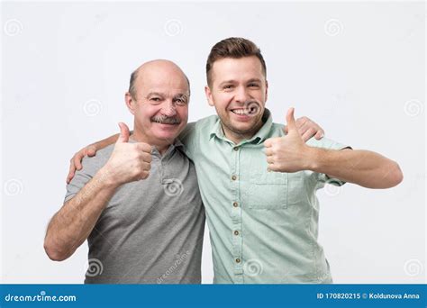 Two Caucasian Mature Men Father And Son Holding Thumbs Up Approving Your Choice Stock Image