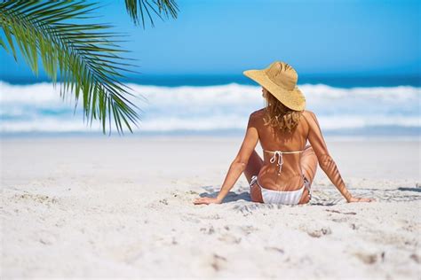 Praia tropical e mulher relaxam na ilha na areia para férias de