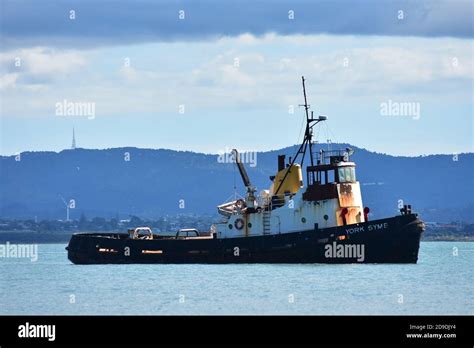 Tugboat With Black Hull And White Cabin With Rust Marks On Surface Of