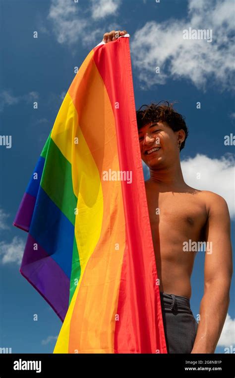 Portrait d un jeune gay hispanique regardant la caméra portant le drapeau LGBT Focus sur l