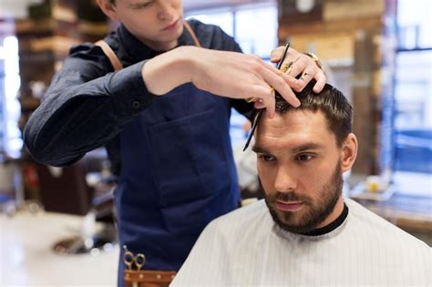 Concepto de aseo peluquería y personas hombre y barbero con peine y