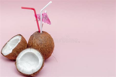 Coconut With Drinking Straw And Umbrella On Pink Background Stock Photo