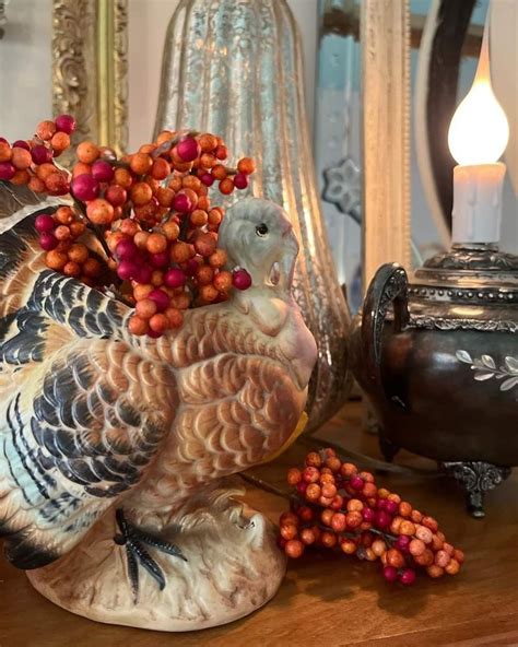 A Turkey Figurine Sitting On Top Of A Wooden Table Next To Some Berries