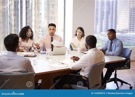 Group Of Business Professionals Meeting Around Table In Modern Office