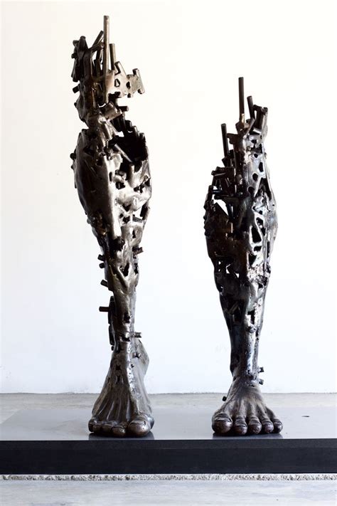 Two Metal Sculptures Sitting Next To Each Other On Top Of A Black