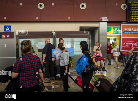 Arrivals area at Tenerife Sur airport with Thomsons rep holding sign and assisting holidaymakers ...