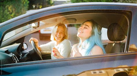 Young Women Singing Along To Music In Their Car By Stocksy