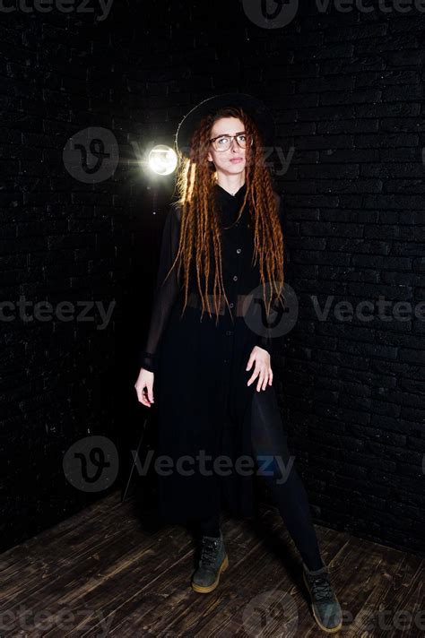 Studio Shoot Of Girl In Black With Dreads At Glasses And Hat On Brick