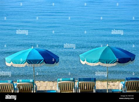 Beach resort umbrella and lounger Stock Photo - Alamy