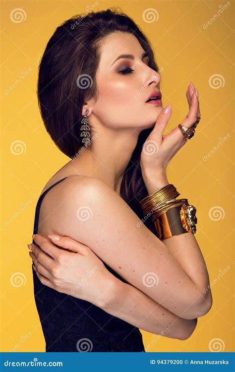 Sensual Beautiful Brunette Woman Posing In Black Dress And Gold Stock