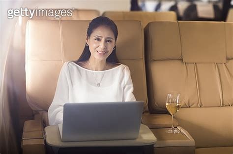 Elegant mature woman using laptop on airplane 이미지 a11364050 게티이미지뱅크