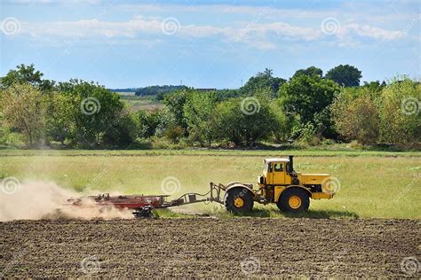 Yellow Tractor On Land Cultivating Agricultural Tractor On Cultivation