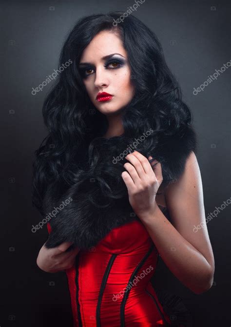 Sexy Brunette In Red Corset Fur And Long Hair In Studio Stock Photo By FlexDreams