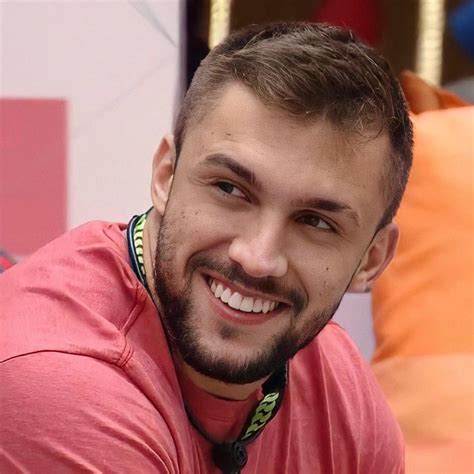 A Close Up Of A Person With A Smile On His Face And Wearing A Pink Shirt