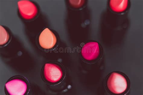 Group Of Red Pink And Nude Lipsticks With Different Colors And Textures On Dark Table Stock