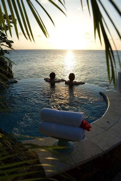 Two People Are Swimming In The Ocean At Sunset