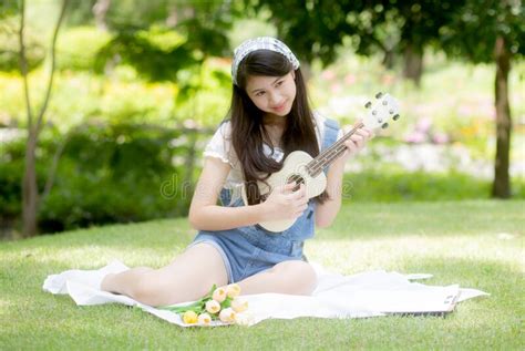 Happiness Young Asian Woman Sitting And Playing Ukulele While