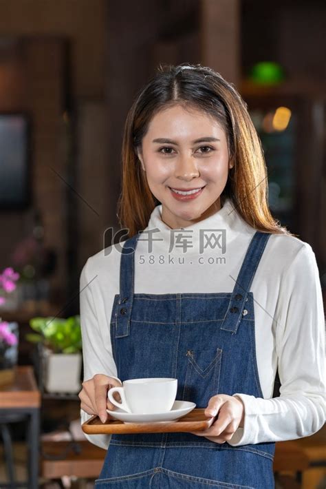 美丽的亚洲咖啡师在咖啡馆里拿着一杯咖啡的画像美女服装高清摄影大图 千库网