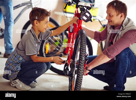 Father Helping His Son Fix A Bicycle Stock Photo Alamy