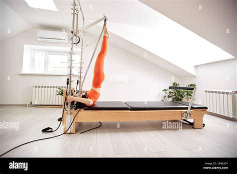 Une Jeune Fille Fait Pilates Sur Un Lit Reformeur Dans Un Studio Lumineux Un Brunette Mince