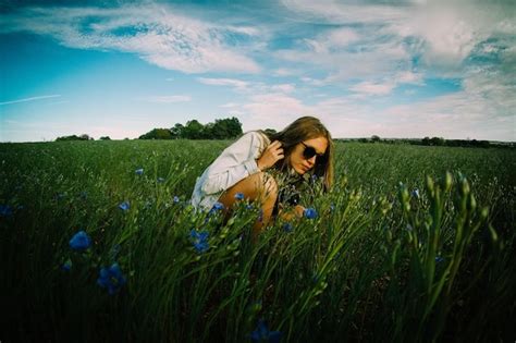 Premium Photo Woman Crouching On Field Against Sky