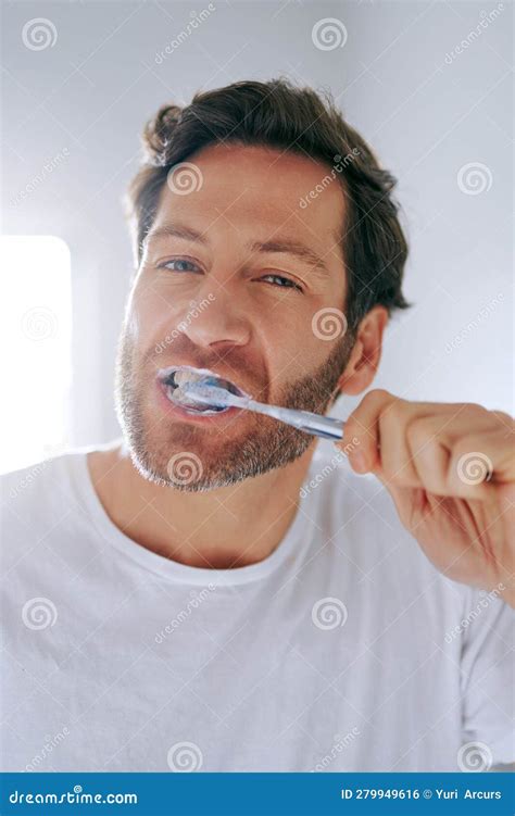 Polishing Those Toothies A Handsome Middle Aged Man Brushing His Teeth