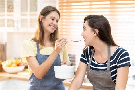 Happy Same Sex Couple Feed Each Other At Kitchen Cheerful Lgbtq