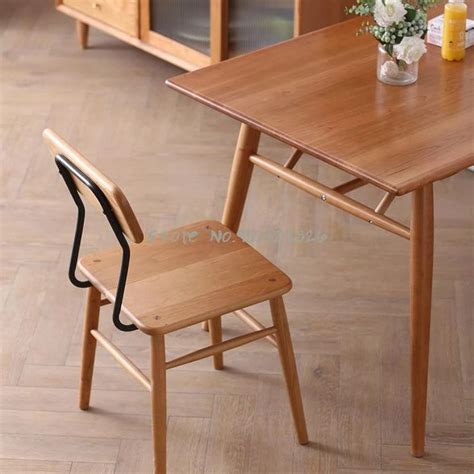 A Small Wooden Table And Chair In A Room With Wood Flooring On The Side